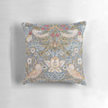 A close-up view of a decorative pillow featuring the iconic "Strawberry Thief" pattern designed by William Morris.
