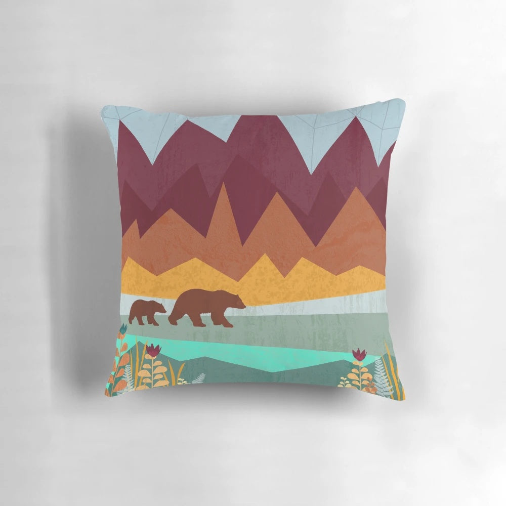 A vibrant, nature-inspired pillow featuring a mother bear and her cub in a scenic mountain landscape.