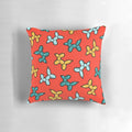 Colorful pillow with a repeating pattern of illustrated balloon animal dogs in red, yellow, and blue