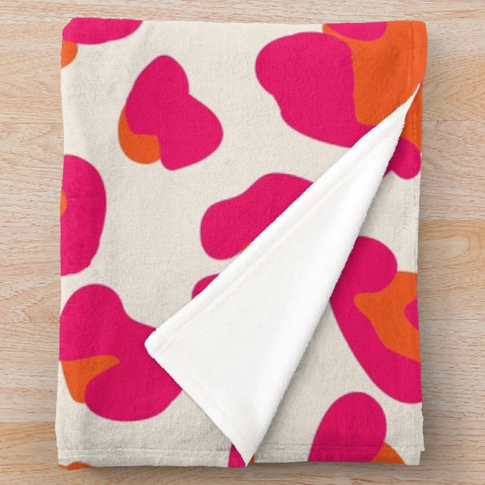 Soft and cozy leopard print plush blanket in vibrant hot pink and orange colors