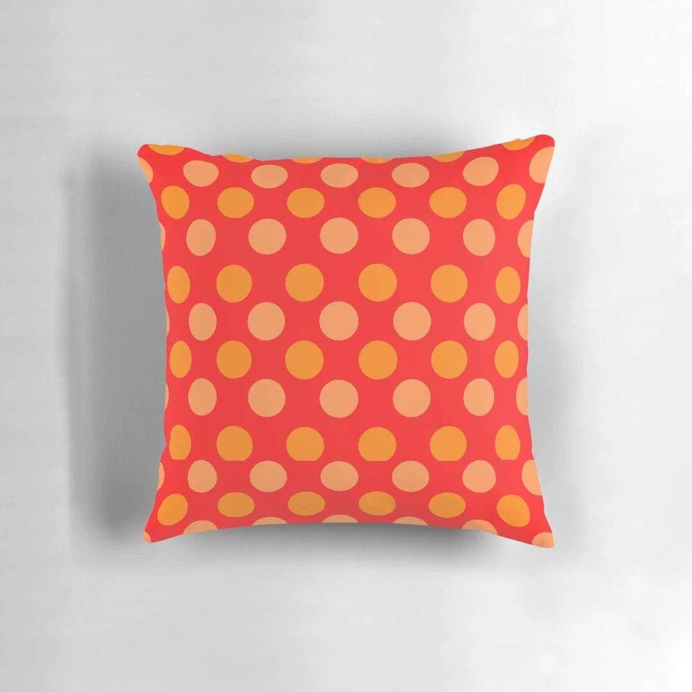 Bright orange and red polka dot patterned throw pillow with a geometric design on a red background.