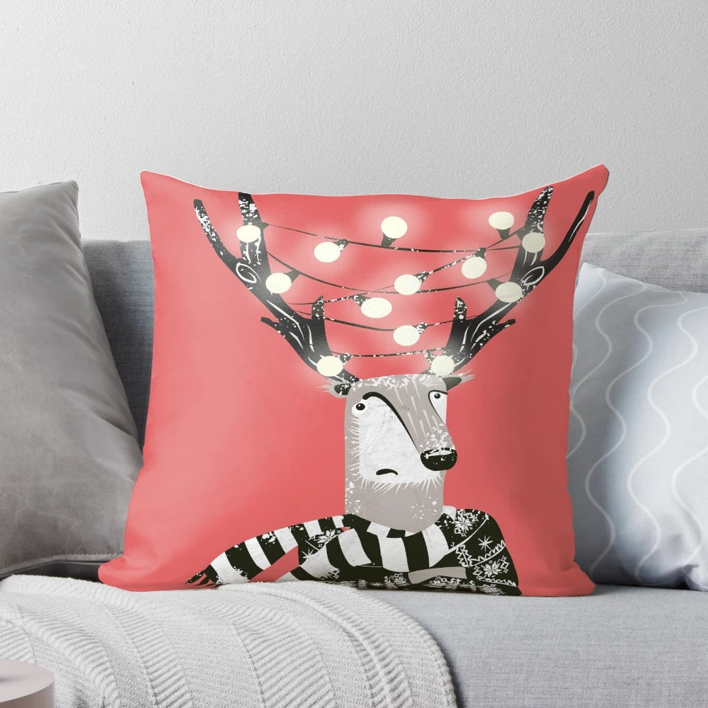 A bright and festive reindeer Christmas pillow with white snow and twinkling lights.