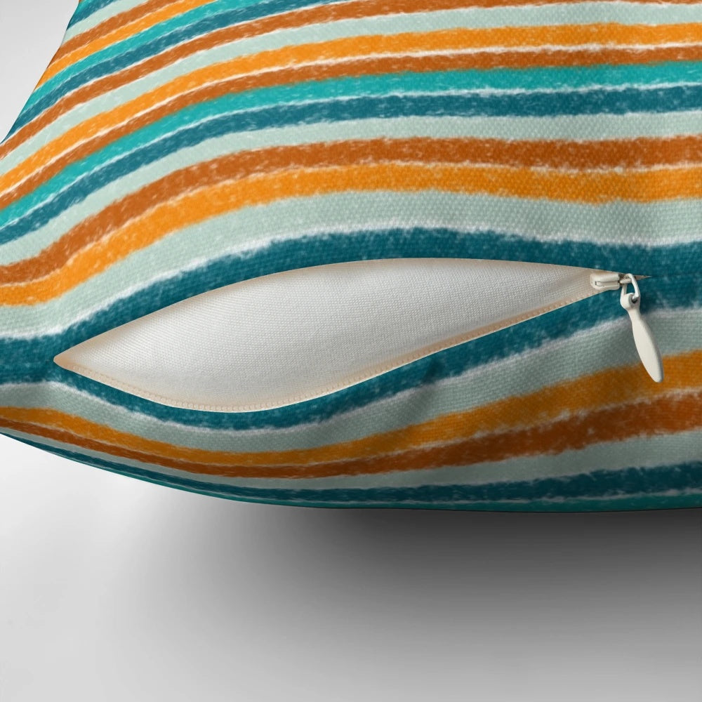 A vibrant and textured summer striped pillow in shades of orange, rust, turquoise, teal, and white.