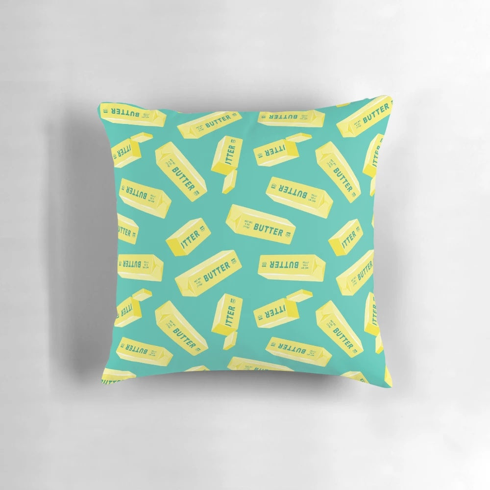 Teal pillow featuring a butter design, perfect for butter lovers and kitchen decor