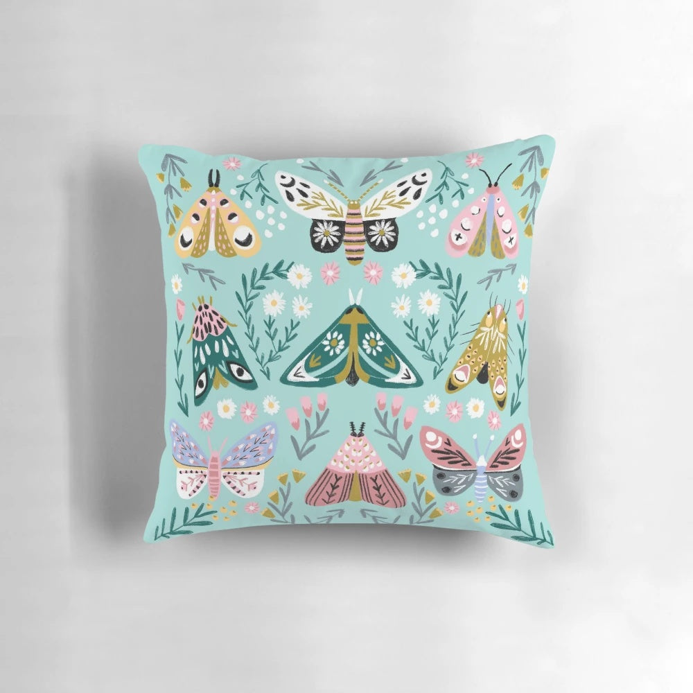 Vibrant butterfly garden design featuring colorful daisies, roses, and butterflies on a decorative pillow.