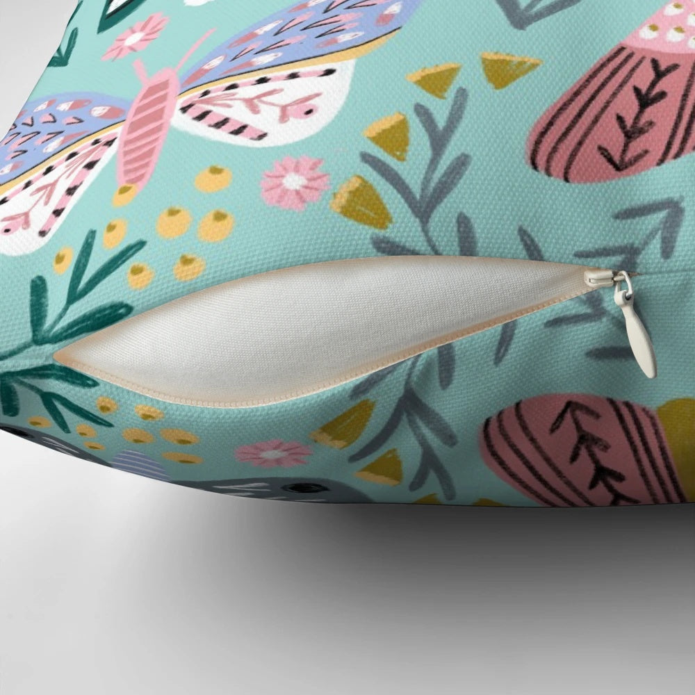 Vibrant butterfly garden design featuring colorful daisies, roses, and butterflies on a decorative pillow.