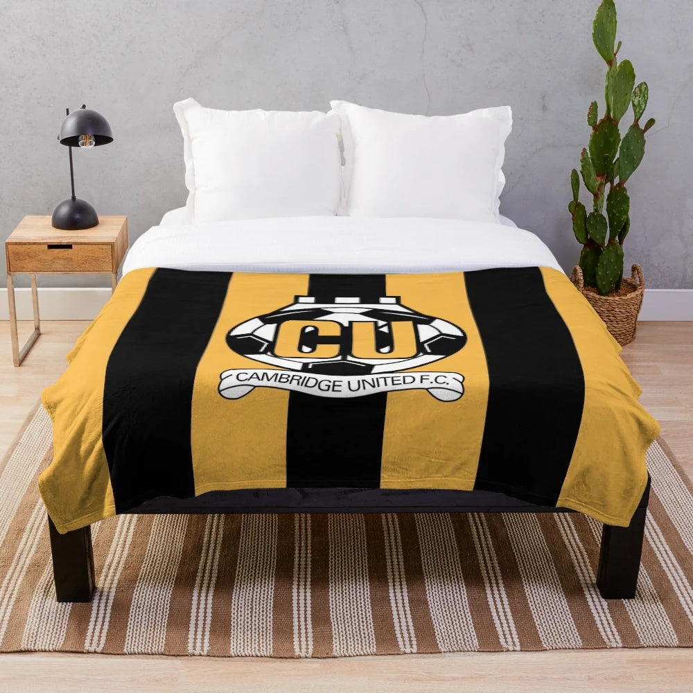 Cambridge United FC logo inspired plush blanket with striped design