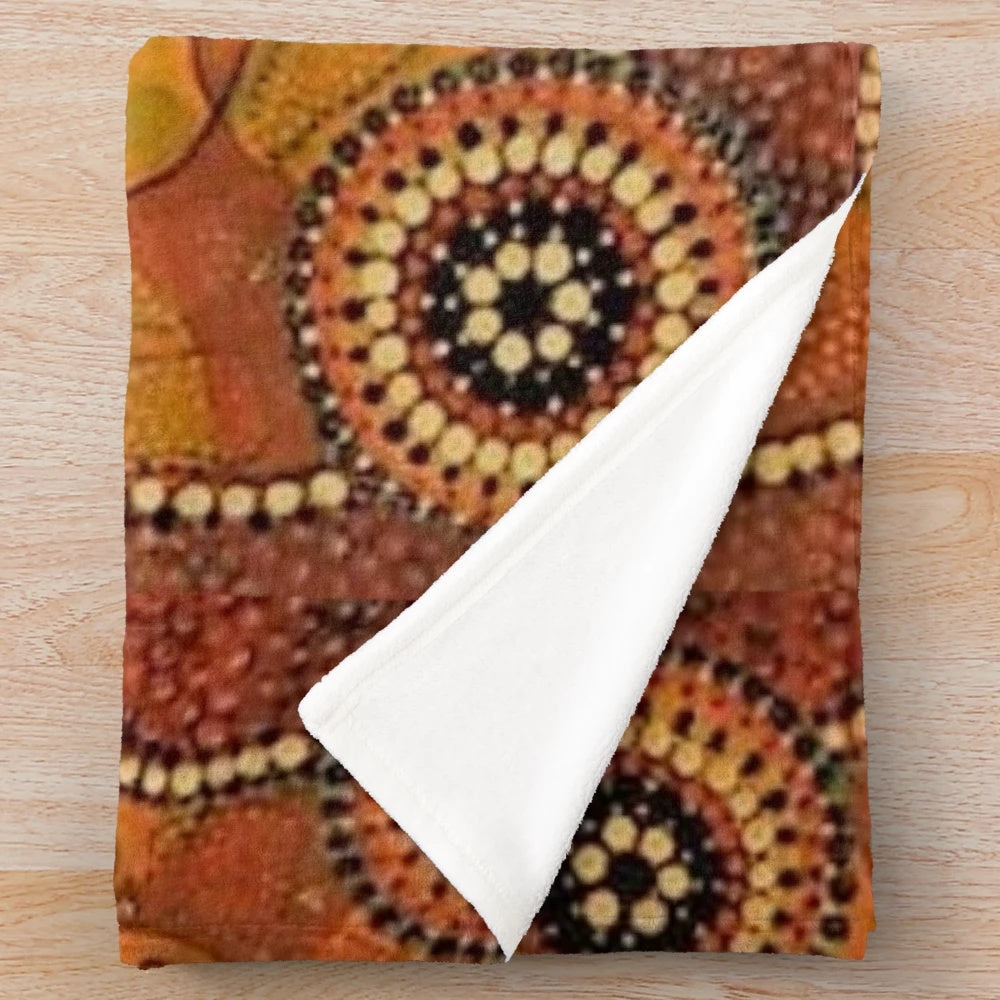 Closeup of a plush blanket featuring aboriginal-inspired dot painting design