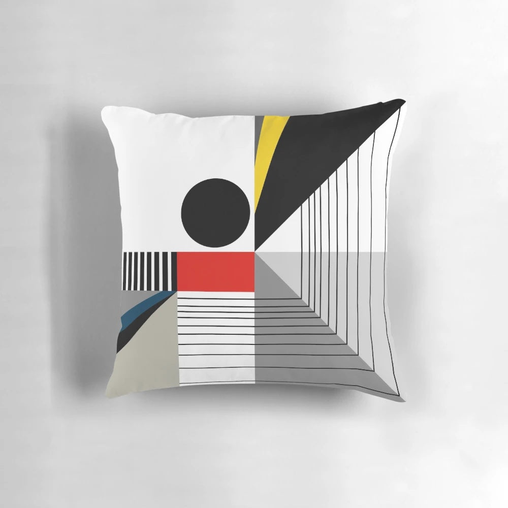 A black and white abstract geometric pillow with red and yellow accents, showcasing a modern Bauhaus-inspired design.