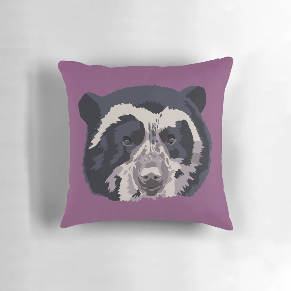 A close-up portrait of an adorable Andean or spectacled bear face printed on a high-quality pillow.