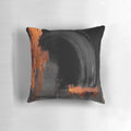 Black and orange abstract art design on a decorative throw pillow
