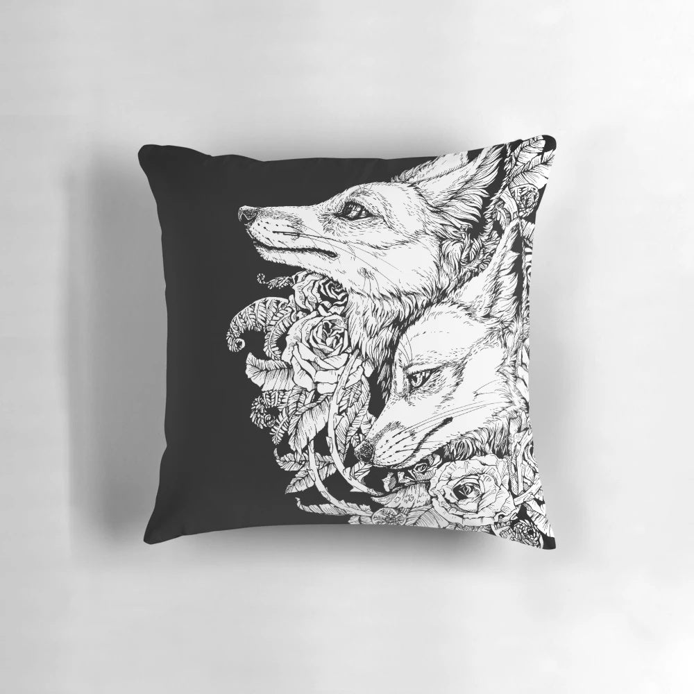 A black and white pillow with a design featuring a fox surrounded by roses and floral elements