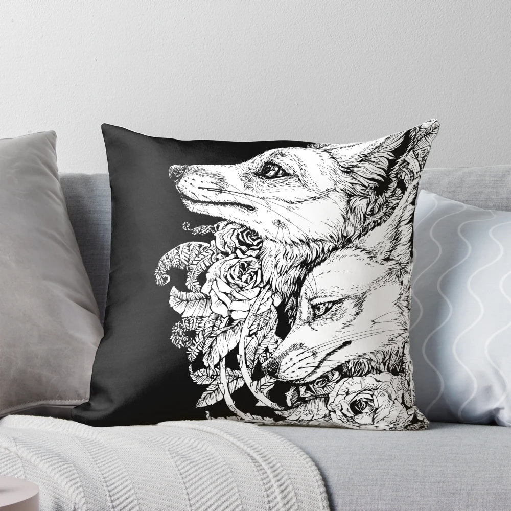 A black and white pillow with a design featuring a fox surrounded by roses and floral elements