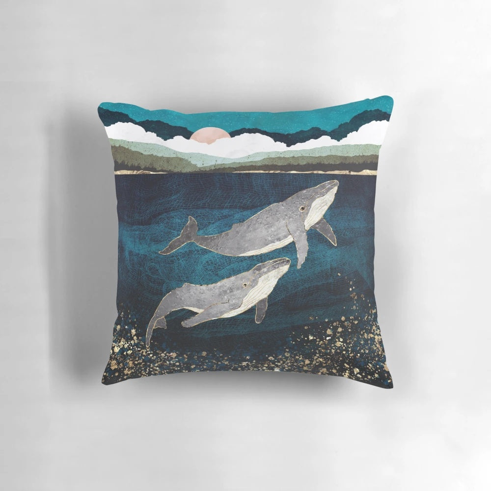 Pillow featuring a contemporary, abstract design of a whale pod in the ocean.