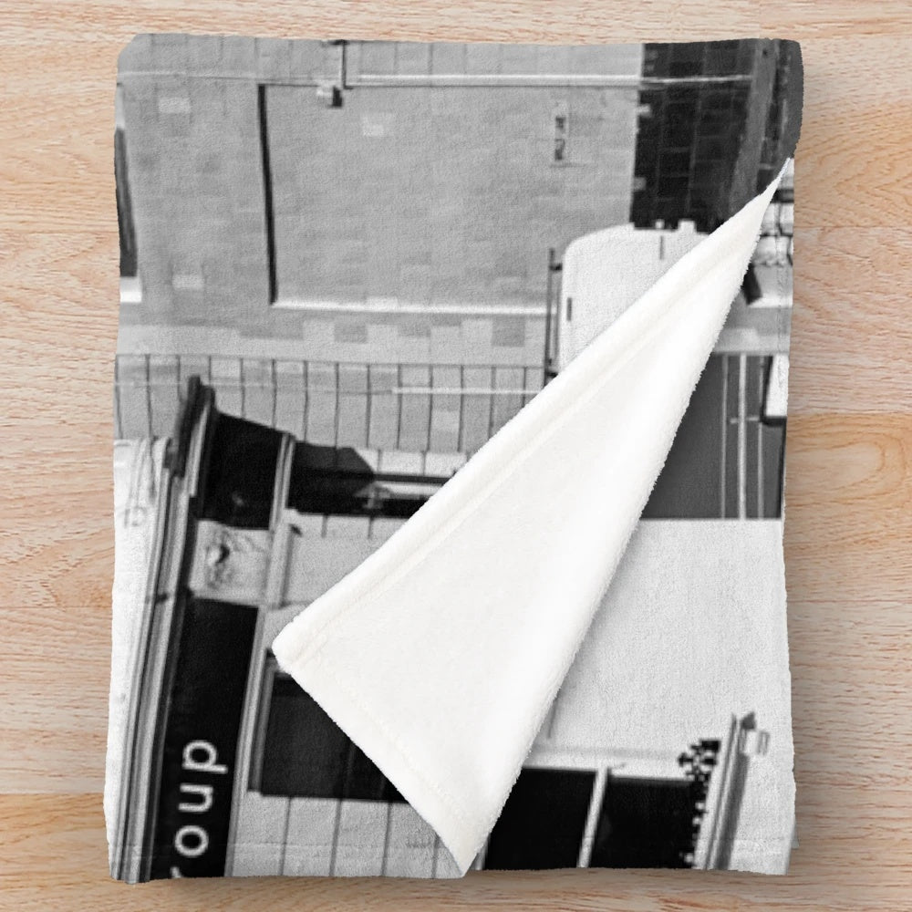 Plush blanket featuring a black and white image of a street scene in Brighton, England with a cinema and cars