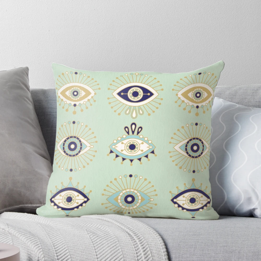 Decorative throw pillow with a vibrant evil eye design in shades of blue, gold, and mint.