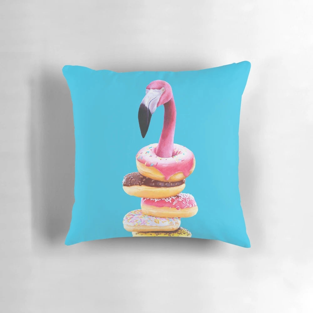 A vibrant pink flamingo perched atop a delectable doughnut-shaped pillow, creating a surreal and whimsical home accent.