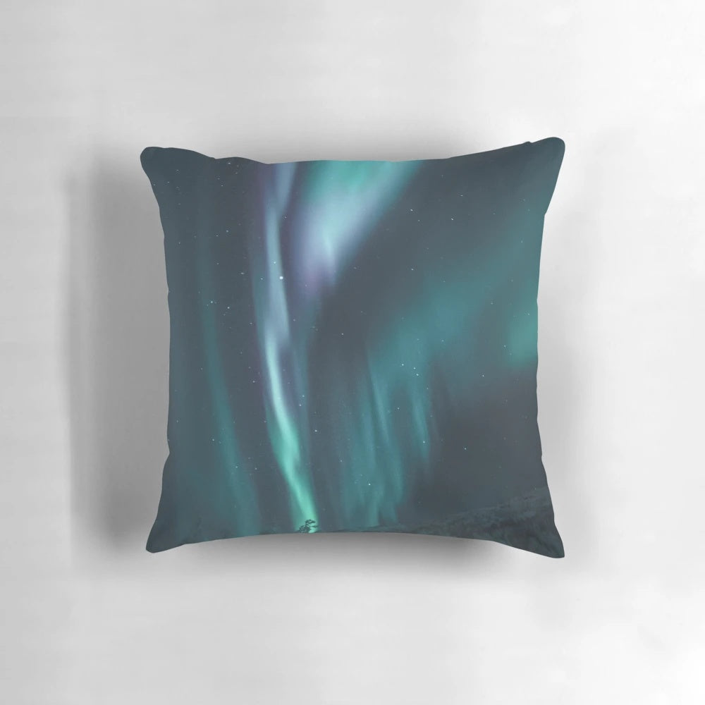 Vibrant blue and green northern lights illuminating a snowy night sky