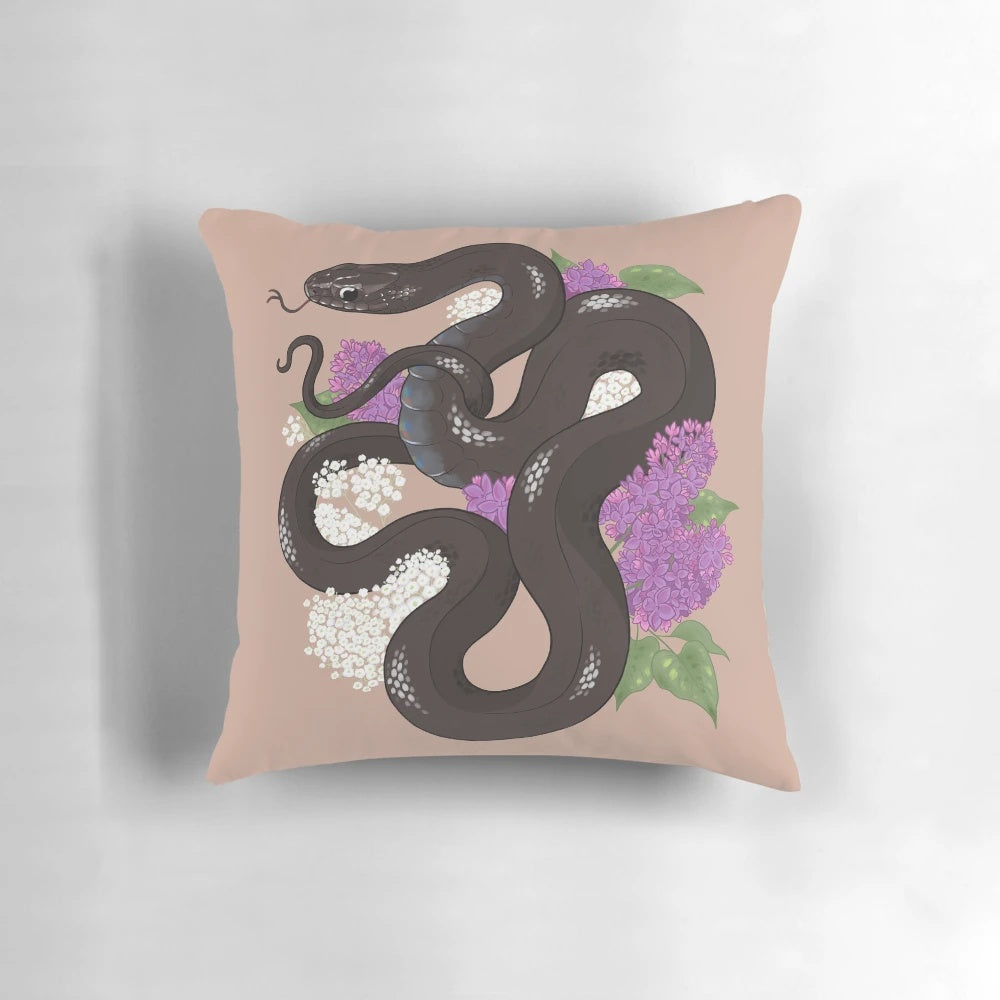 A decorative throw pillow featuring a beautiful Mexican black kingsnake coiled among lilac flowers.