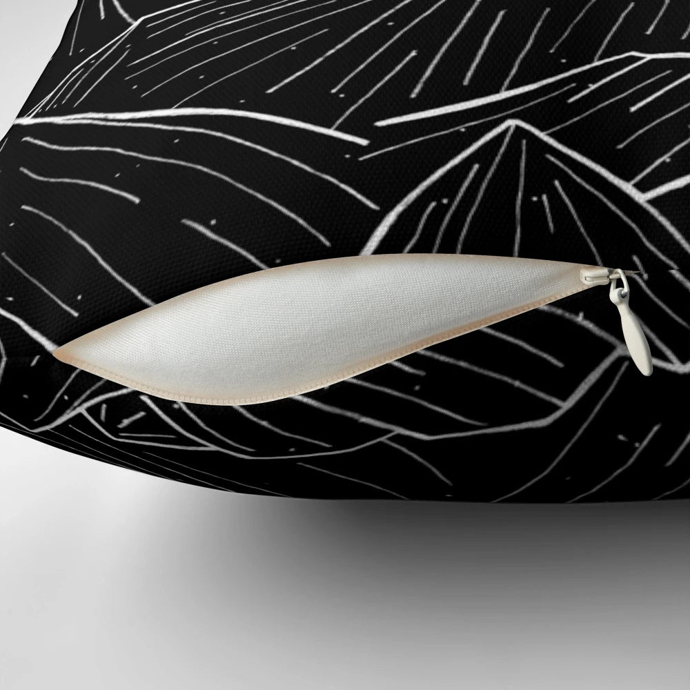 A black and white decorative pillow featuring a minimalist mountain landscape design.
