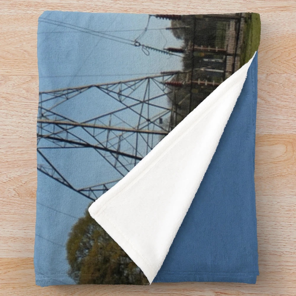 Plush blanket featuring silhouettes of electricity pylons against a countryside landscape