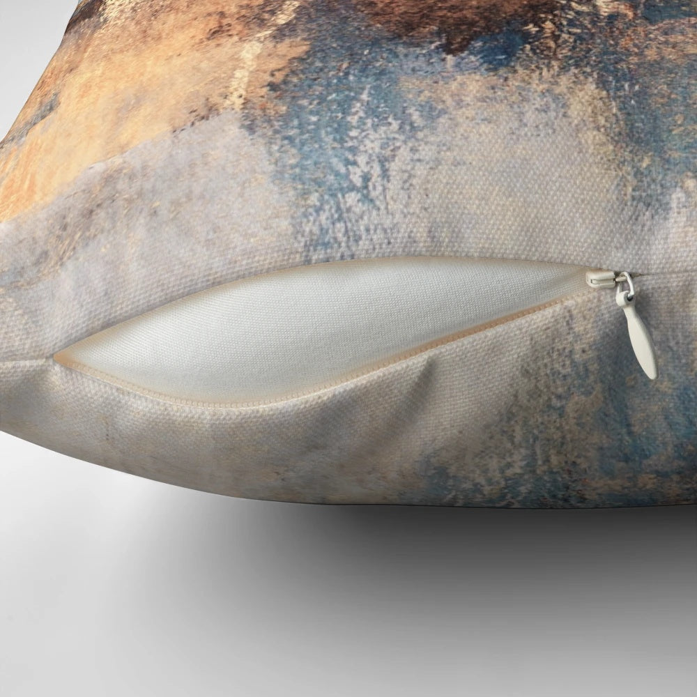 Stunning abstract art pillow with golden accents and a modern, storm-like design