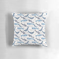 Vibrant watercolor painting of humpback, orca, narwhal, and sperm whales on a blue and turquoise beach-themed throw pillow.