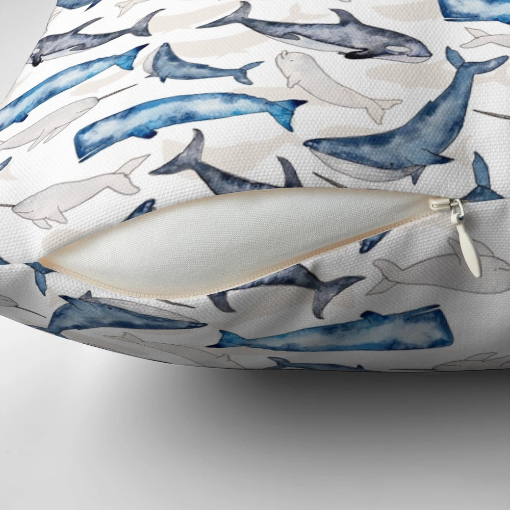 Vibrant watercolor painting of humpback, orca, narwhal, and sperm whales on a blue and turquoise beach-themed throw pillow.