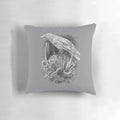 A striking monochrome pillow featuring a detailed raven design with nature elements like flowers, leaves, and vines.