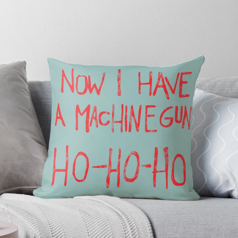 A plush pillow featuring the iconic "Now I Have a Machine Gun Ho-Ho-Ho" quote from the classic film Die Hard, featuring Bruce Willis as John McClane.