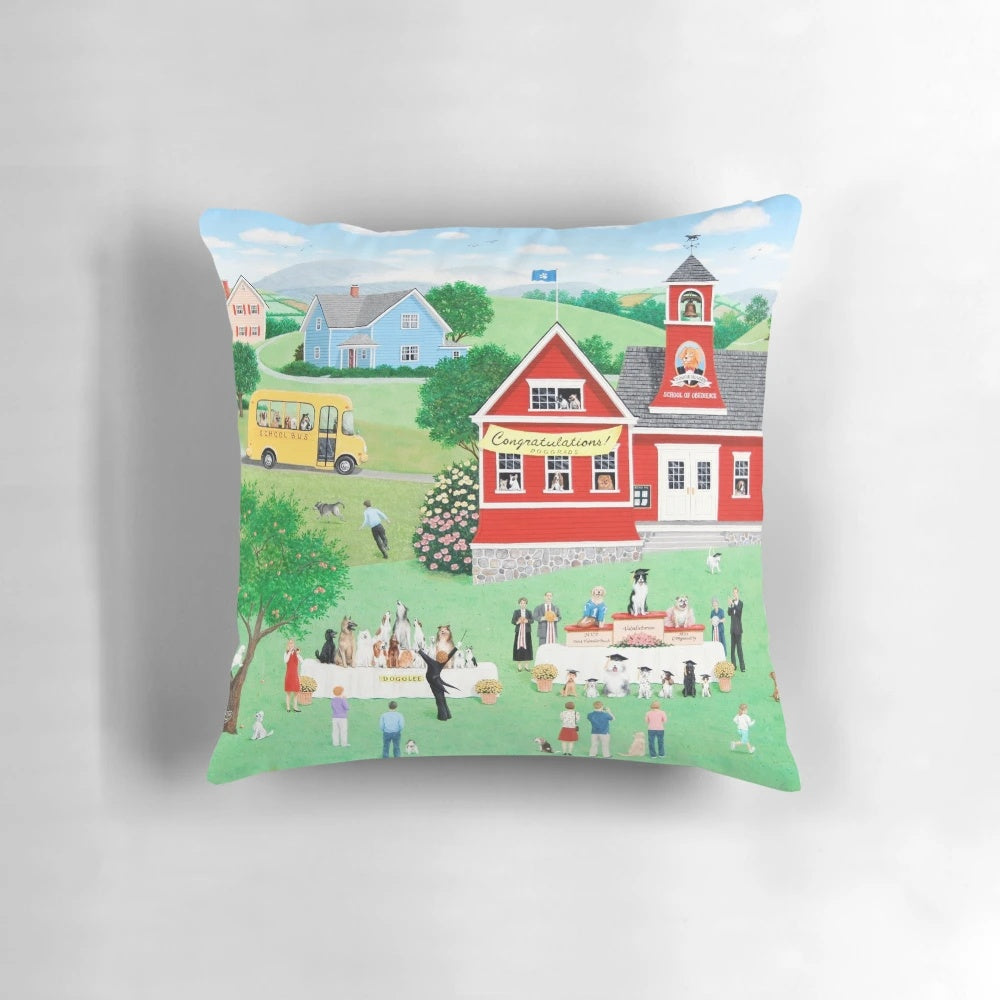 Whimsical dog-themed graduation pillow featuring a naive landscape with a school bus and graduates