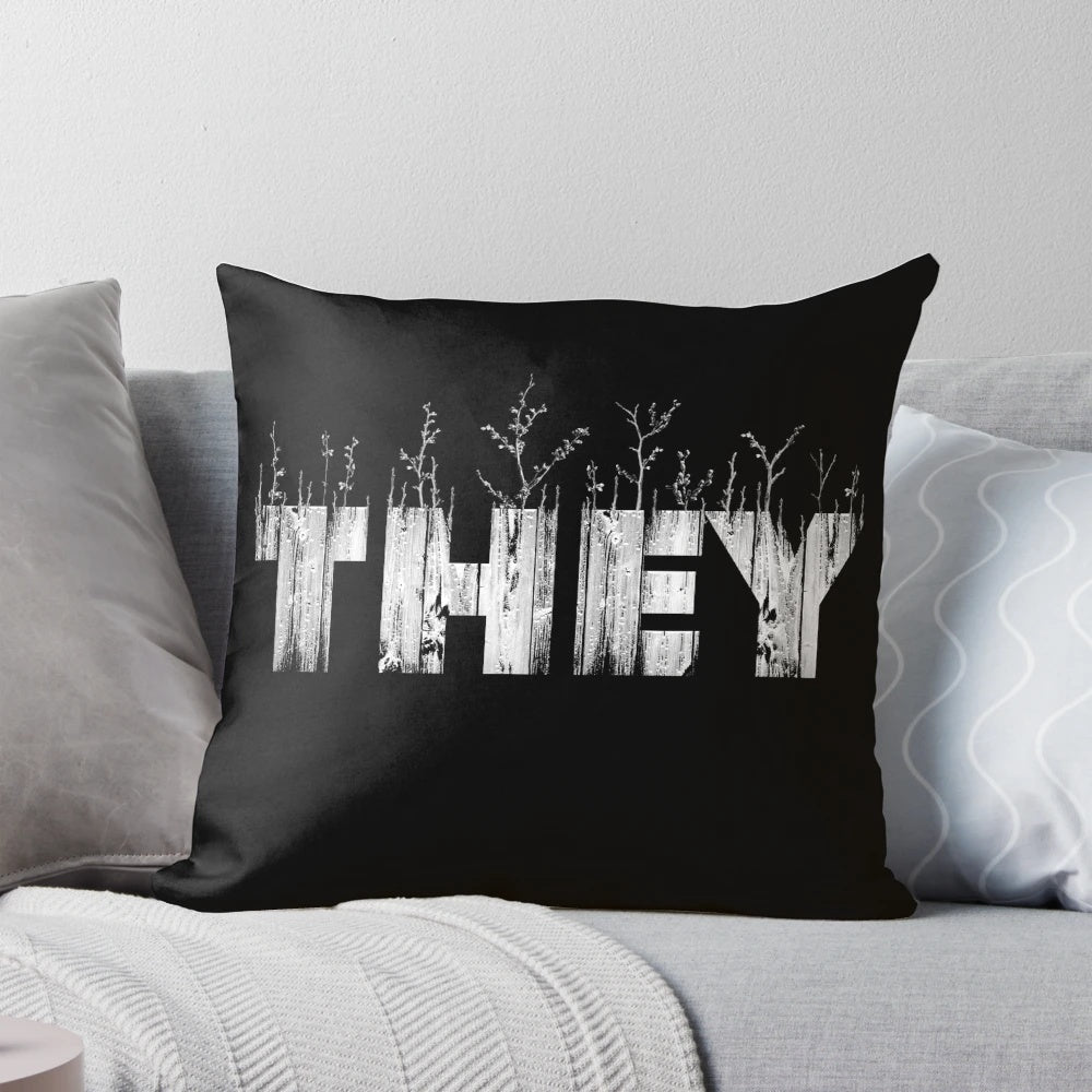 A cozy, nature-themed pillow with the text 'THEY' printed on it, representing gender identity and self-expression.