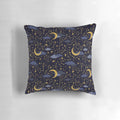 A decorative pillow featuring a cosmic design of stars, moons, and galaxies in gold and dark blue.