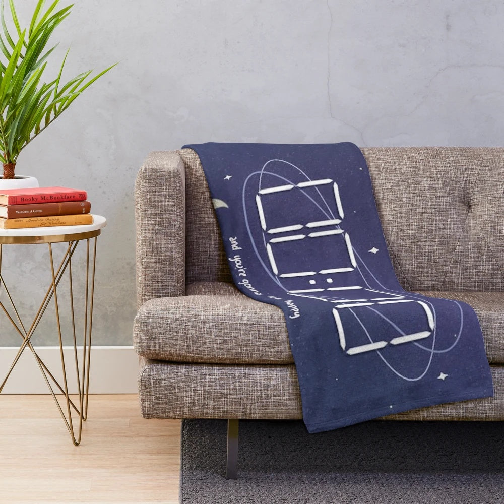 Celestial-inspired plush blanket with moon phase and sun and moon design
