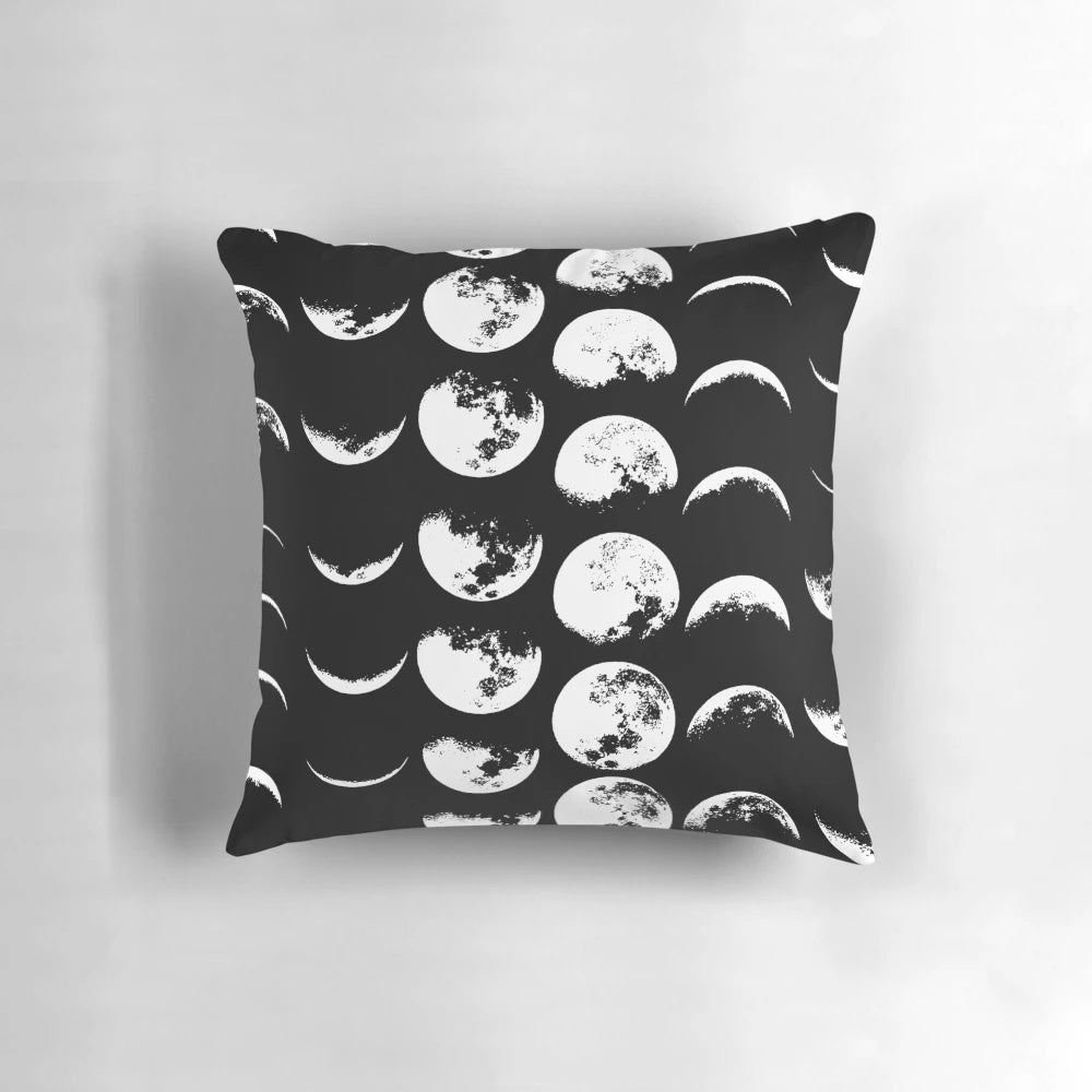 A black and white pillow with the phases of the moon design, perfect for adding a touch of celestial style to any space.