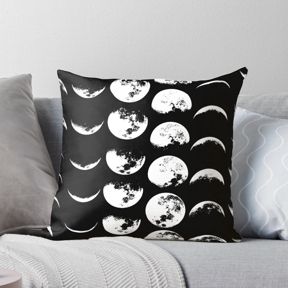A black and white pillow with the phases of the moon design, perfect for adding a touch of celestial style to any space.
