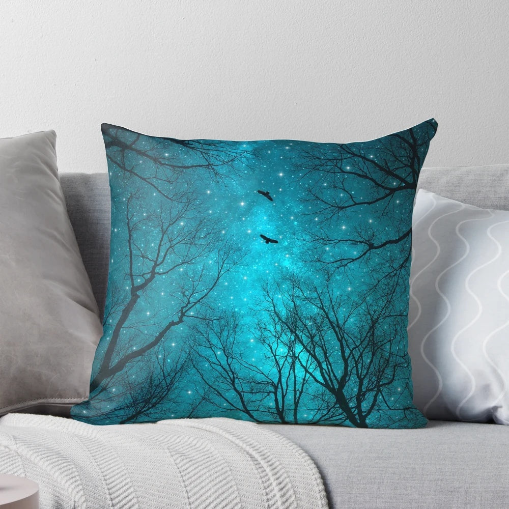 A decorative throw pillow featuring a starry night sky, galaxy, and silhouetted trees against a mint teal background.