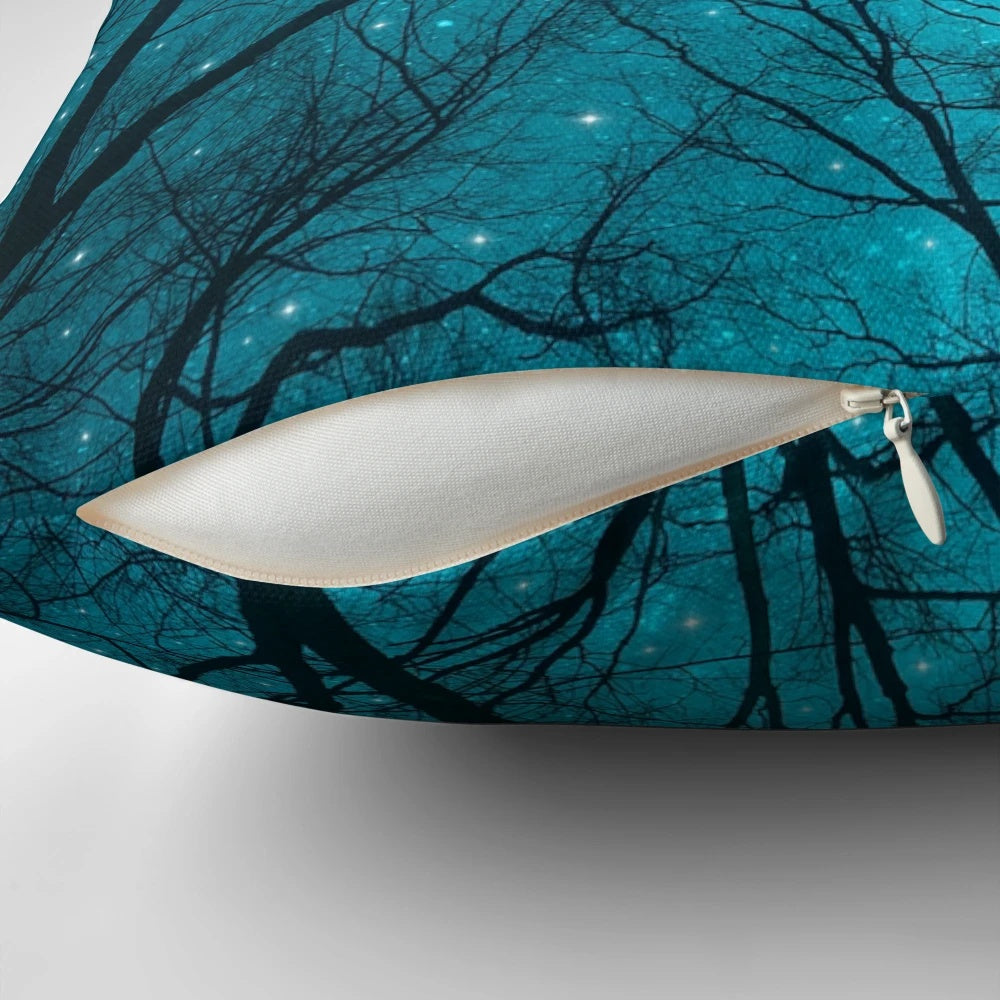 A decorative throw pillow featuring a starry night sky, galaxy, and silhouetted trees against a mint teal background.