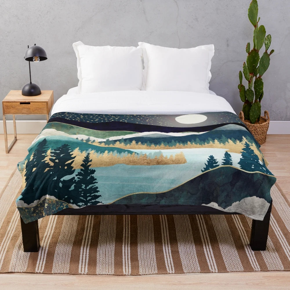 Plush blanket with a nature-inspired celestial design featuring stars, a mountain lake, and evergreen forest