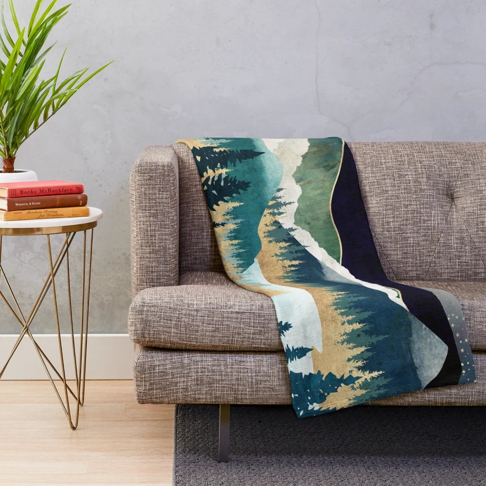 Plush blanket with a nature-inspired celestial design featuring stars, a mountain lake, and evergreen forest