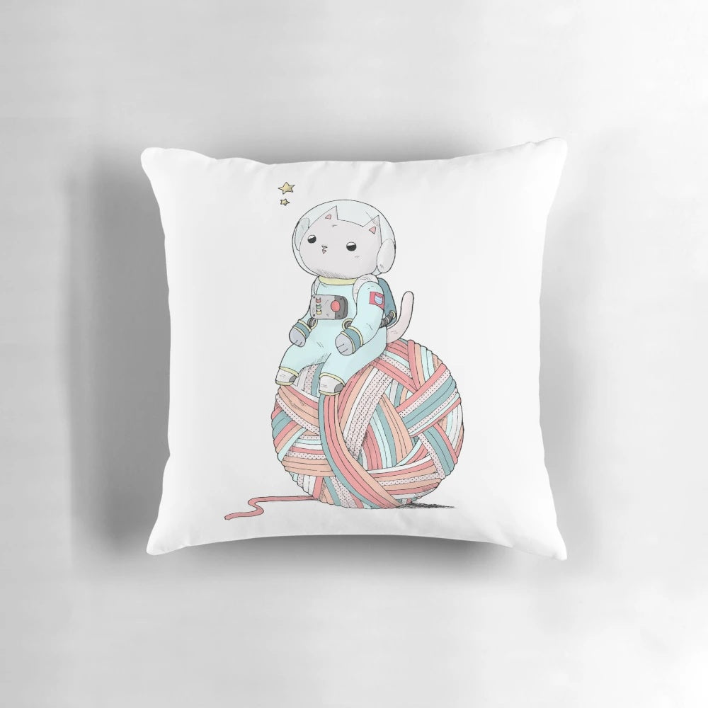 A plush pillow depicting a cute space cat sitting on a yarn ball against a starry, galaxy background.