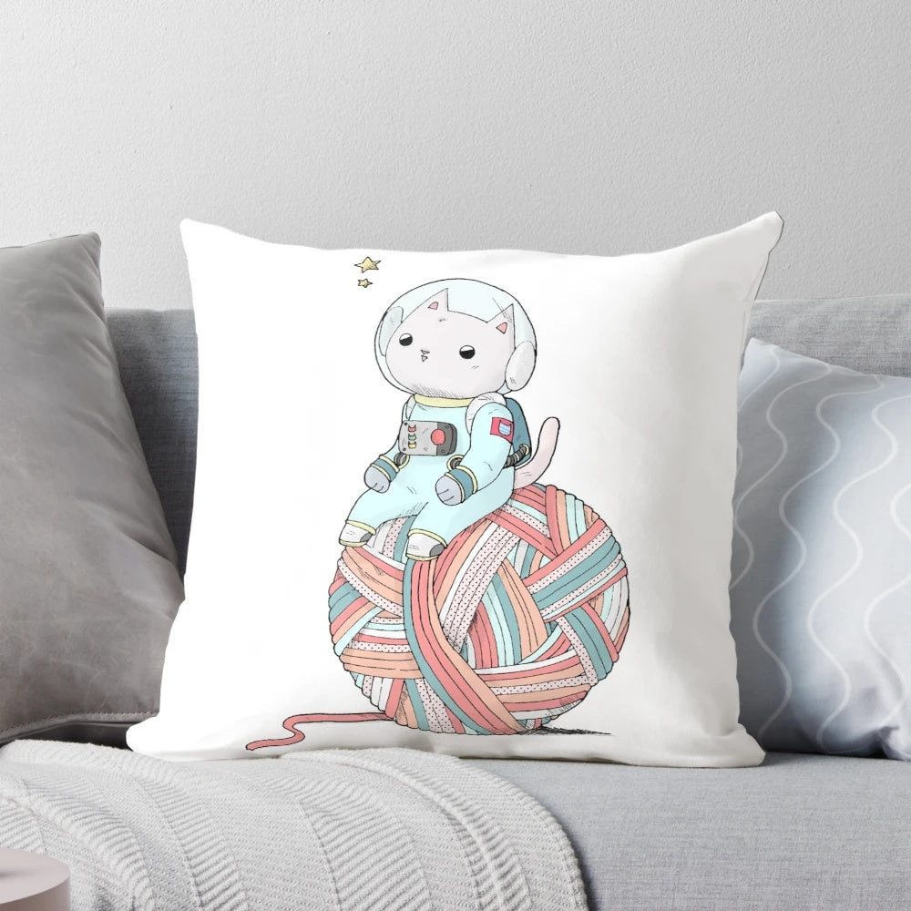 A plush pillow depicting a cute space cat sitting on a yarn ball against a starry, galaxy background.