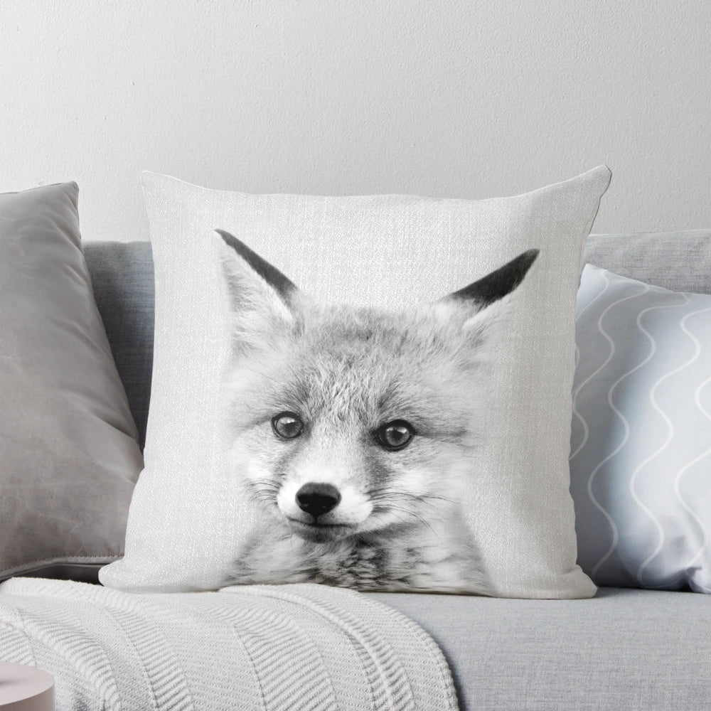 A black and white portrait illustration of a cute baby fox on a decorative throw pillow