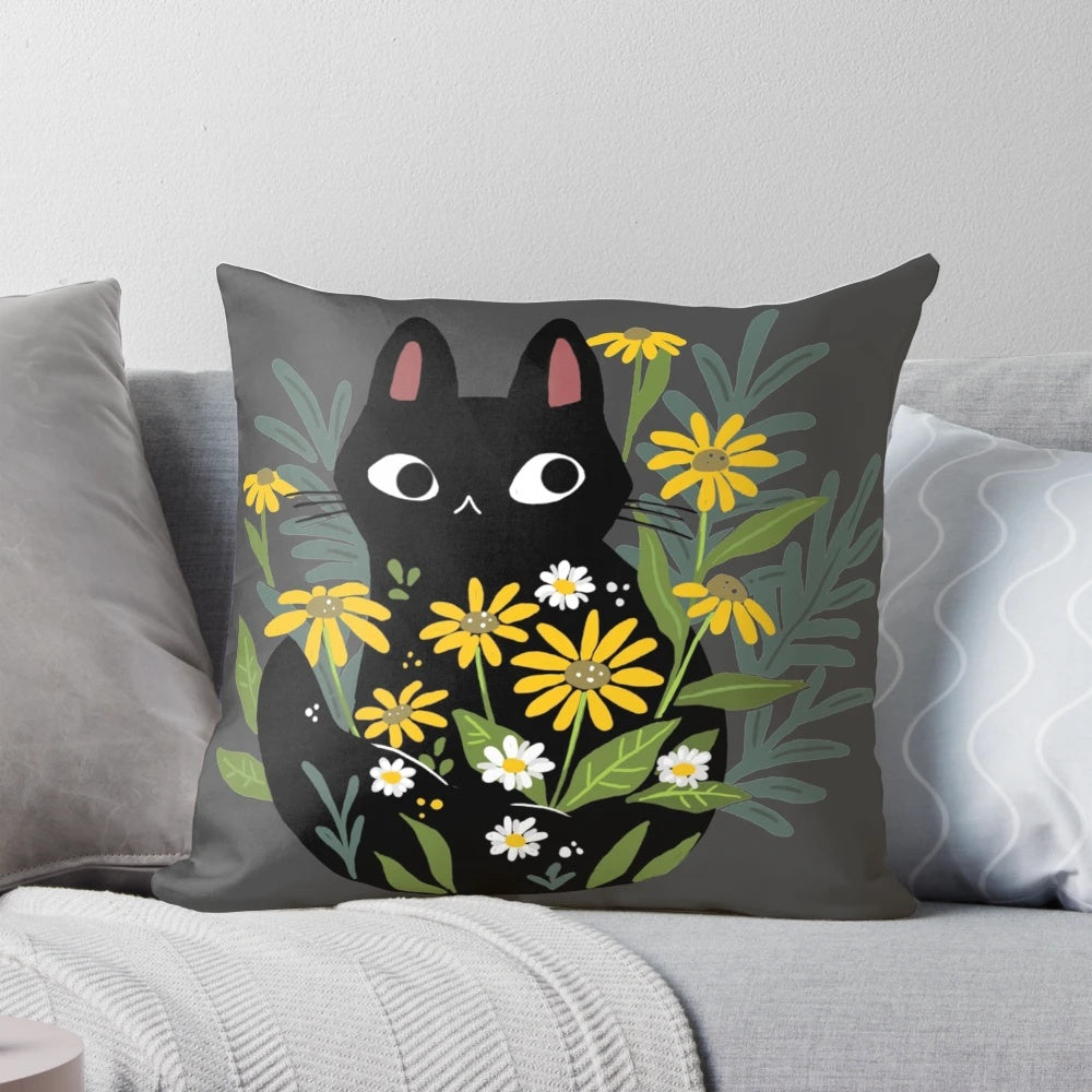 A black cat with vibrant flowers decorating a cozy throw pillow