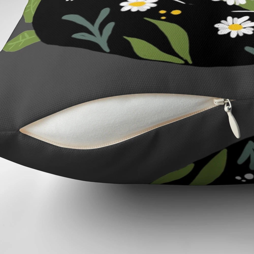 A black cat with vibrant flowers decorating a cozy throw pillow