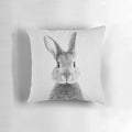 Black and white portrait illustration of a playful rabbit on a soft, plush pillow.