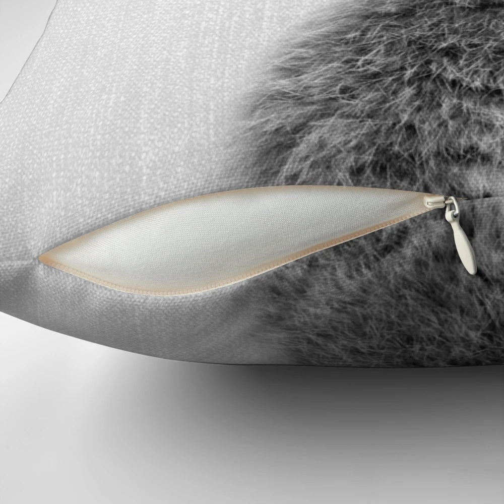 Black and white portrait illustration of a playful rabbit on a soft, plush pillow.