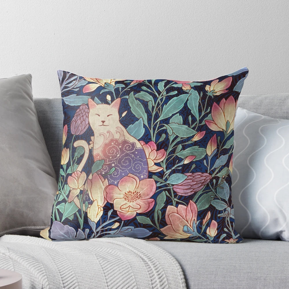 A decorative throw pillow featuring a vintage-inspired pattern with a cat and magnolia flowers.