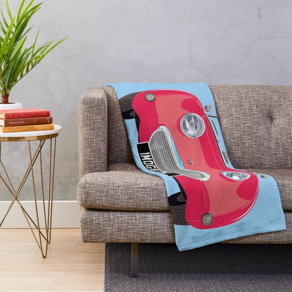 Cherry red plush blanket featuring a frog-eye/bug-eye design inspired by the Austin Healey Sprite