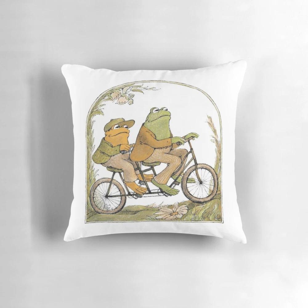 A cozy pillow featuring an illustration of two whimsical amphibian friends, perfect for adding a touch of nature-inspired style to your home.